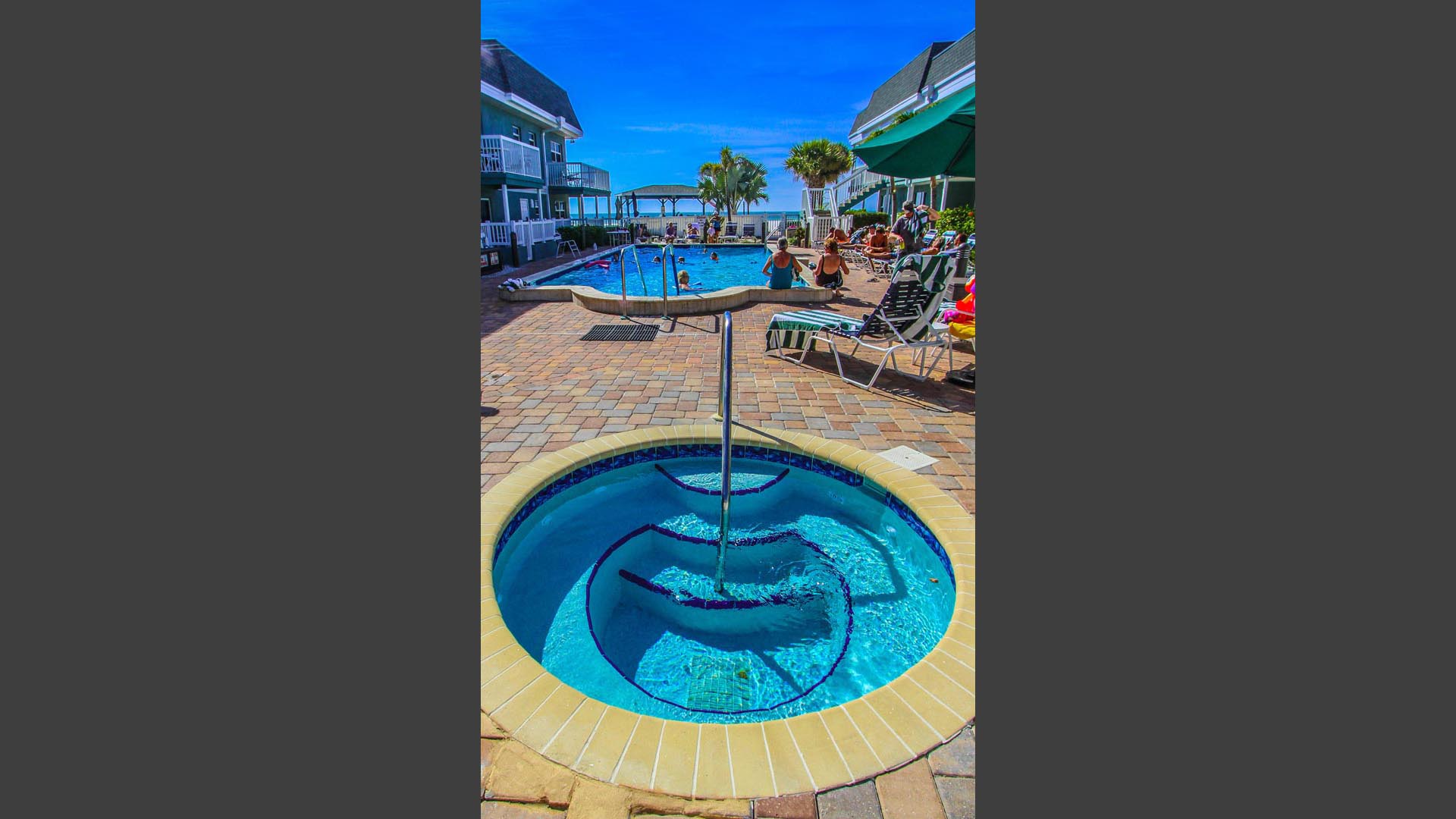 A refreshing view of the outdoor swimming pool and Jacuzzi  at VRI's Mariner Beach Club in St. Pete Beach, Florida.